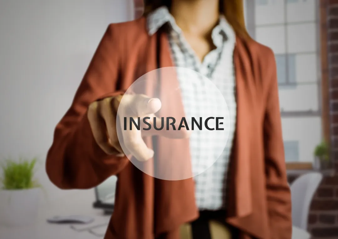 A professional woman in a blazer points towards the word "INSURANCE" in a circular overlay, set in a modern office environment.